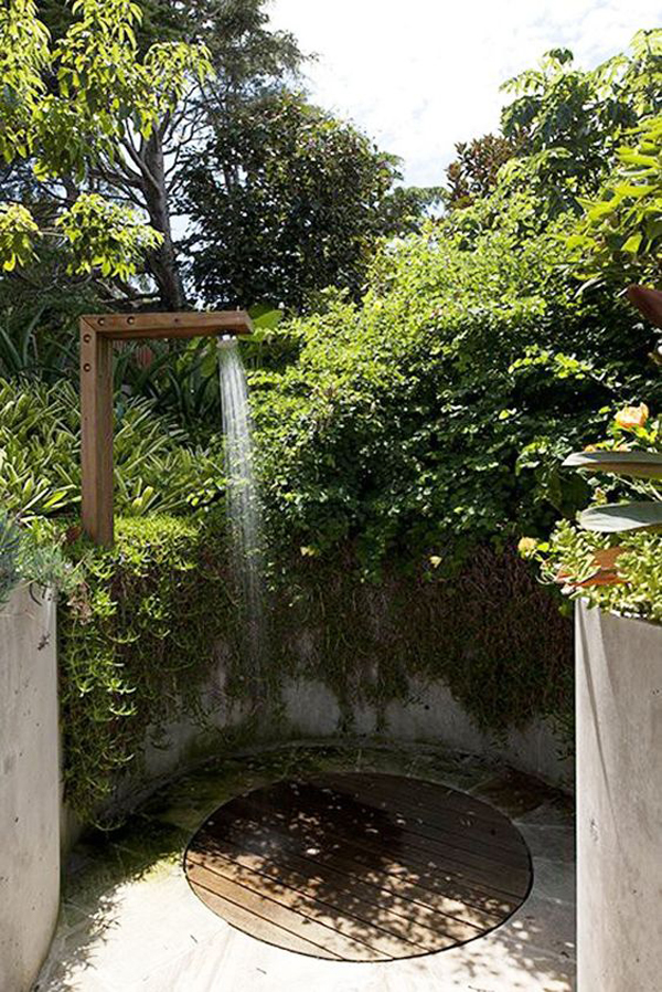 round-outdoor-shower-with-wall-and-plant-barrier